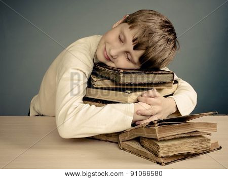 The Teenage boy sleeping on books, smiling