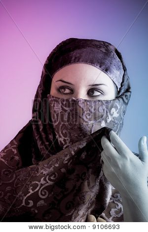 Arabiska beslöjad kvinna klädd lyser med två lampor, rosa och blått