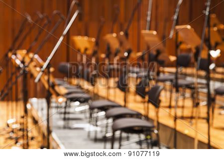 Blurred Orchestra Stage With Chairs And Microhone As Background