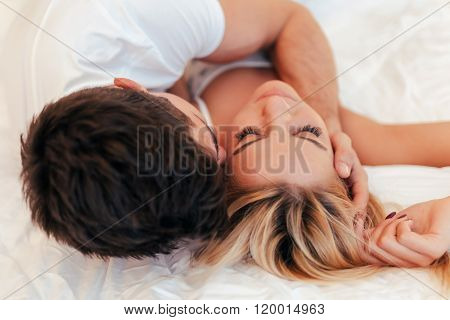 Happy couple in bedroom enjoying sensual foreplay