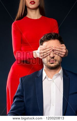 Attractive woman closing eyes of handsome man