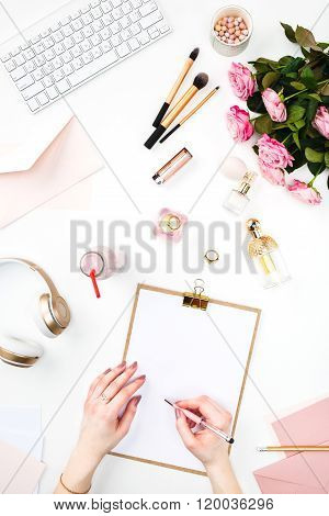 The female hands writing against fashion woman objects
