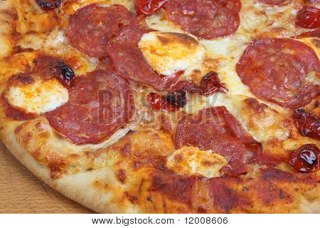 Pizza with salami, mascapone cheese and sun-dried tomatoes