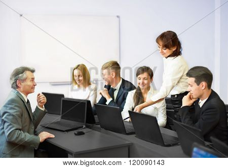 Smiling Business Team With Laptop Computers And Documents