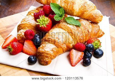 Fresh Tasty Croissants With Berries On Wooden Background