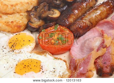 Colazione cucinata con pancetta, salsiccia, uova, funghi e patate fritte