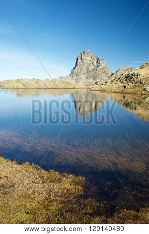 Midi Dossau Peak reflected in a lake. Ossau Valley, Pyrenees National Park, Pyrenees, France.