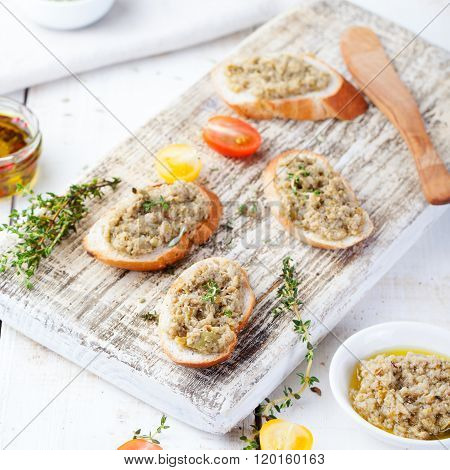 Bruschetta with green olives paste, tapenade on a white wooden background