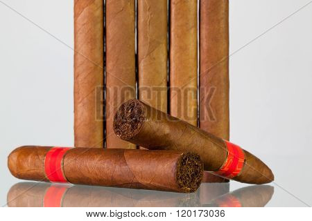 Different Cigars On A  Glass Desk