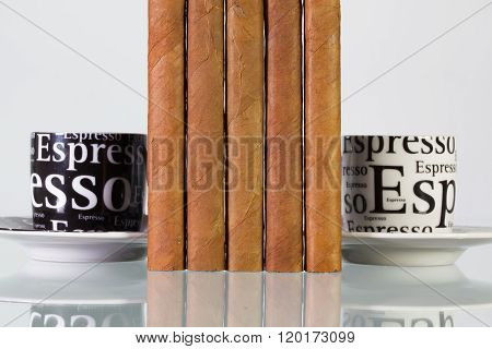 Different cigars and cups of coffee on a glass table and white background