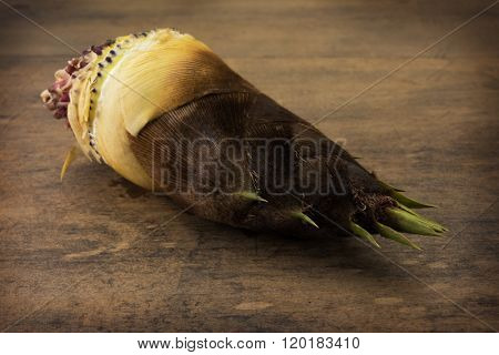 Fresh harvested bamboo shoot, on rustic wooden table.