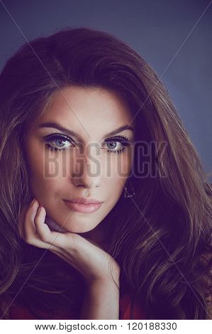 A Studio Portrait Of A Young Woman With Long And Wavy Hair And B