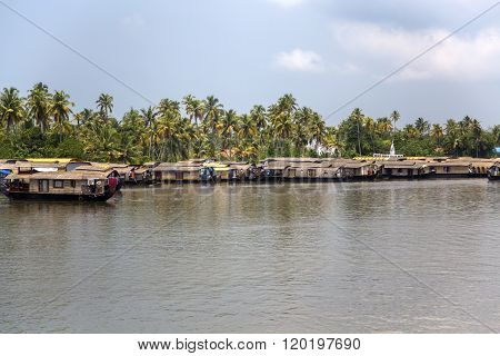 KERALA, INDIA - OCTOBER 16, 2015: Boats at backwaters in Kerala India. The backwaters are an extensive network of 41 west flowing interlocking rivers lakes and canals that center around Alleppey Kumarakom and Punnamada.