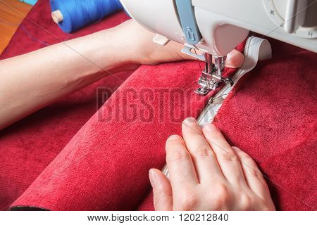 Sewing Machine, Red Fabric And Women's Hands
