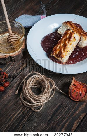 Berry drink. Saucer kissel with cheese casserole and spices on wood