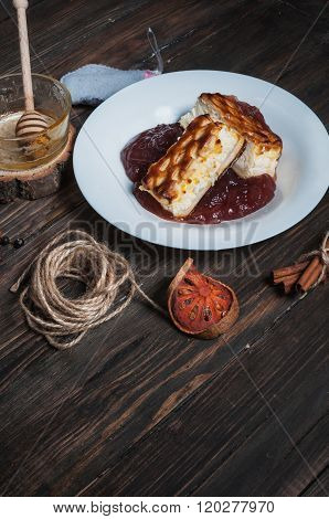 Berry drink. Saucer kissel with cheese casserole and spices on wood