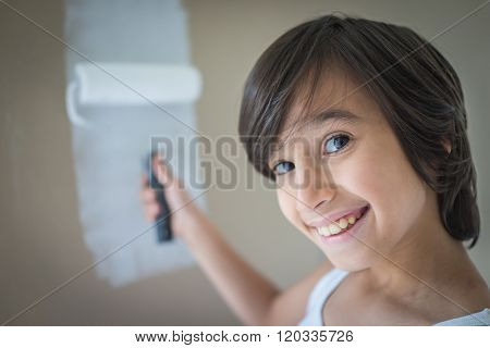 Little cute boy painting on a wall