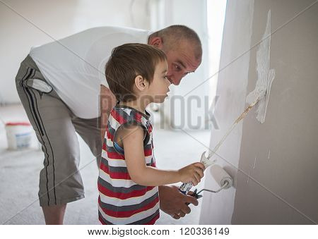 Little cute boy painting on a wall
