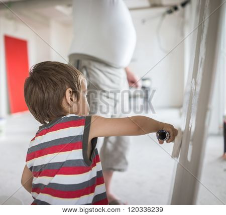 Little cute boy painting on a wall