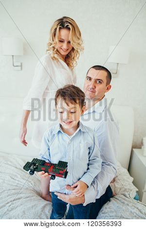 Happy Family In Bedroom.a Pregnant Woman