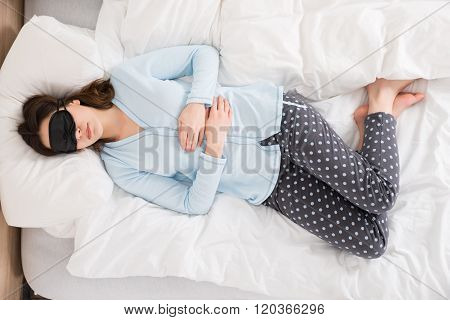 Woman Wearing Eyemask While Sleeping On Bed