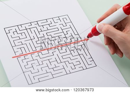 Woman Hand Drawing Straight Red Line Over Maze