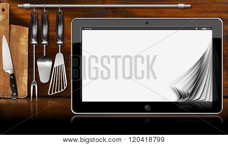 Black tablet computer with blank pages in a kitchen on wooden wall with kitchen utensils. Template for recipes or food menu