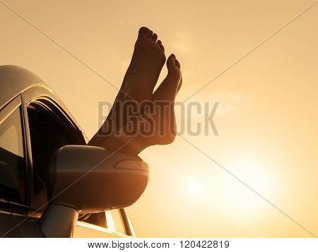 Woman relaxing in a car on road trip.