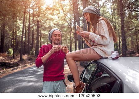 Young couple traveling by car in the forest