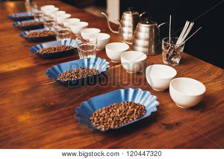Rows of cups, glasses and containers with coffee beans