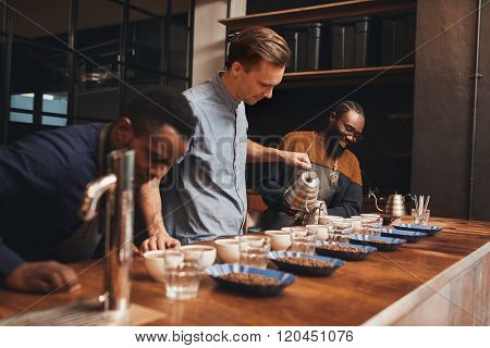 Modern roastery with baristas training to pour perfect coffee