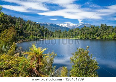 Sunny summer day on the Lake Mapourika on the West Coast of New Zealand's South Island, a popular travel destination for fishing kayaking bird wathing and camping