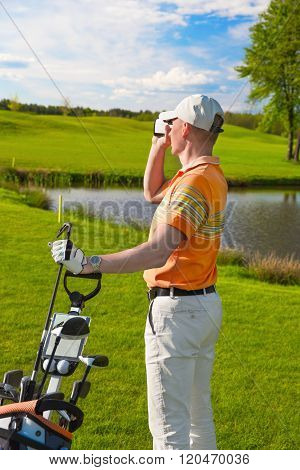man golfer watching into rangefinder