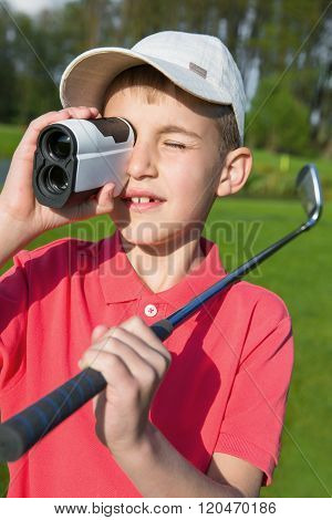 boy golfer watching into rangefinder