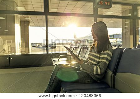 Passenger traveler woman in airport use of tablet at departure hall