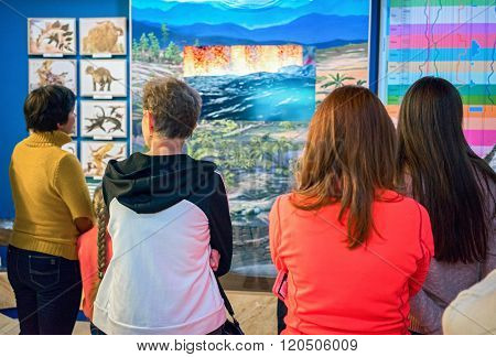Listvianka, Russia - February 15, 2016: Rear View Of People Looking Prehistoric Trees And Dinosaurus