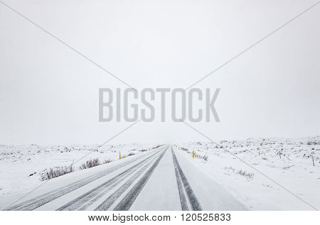 Snow falling on a country road in iceland in the winter