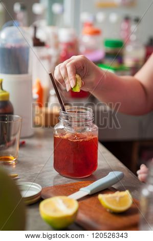 The process of making Thai lemon tea. Woman right hand squeeze lemon into cold tea