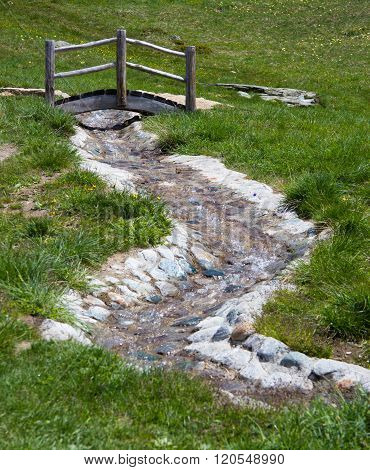 small bridge over a steram in swiss alps
