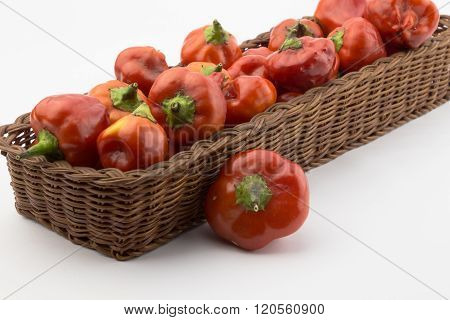 Red Chili Peppers In A Rustic Basket At An Angle Isolated On White