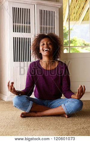 Smiling Young Black Woman Sitting On Floor Practising Yoga