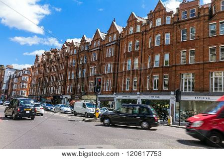 LONDON UK - JUNE 6 2015: Unidentified people and traffic on typical English Brompton road in a summer afternoon