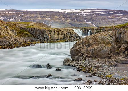 The Skjalfandafljot river in Iceland with the Godafoss waterfall in the back