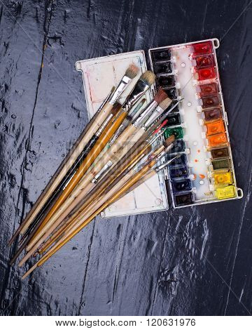 A Set Of Watercolors And Brushes On The Floo