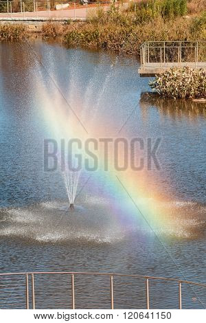 Rainbow Forms From Fountain Spray At Public Park