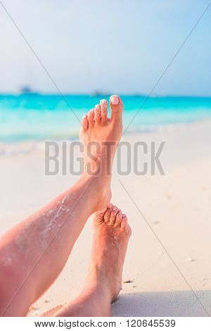 Close up of female feet on white sandy beach
