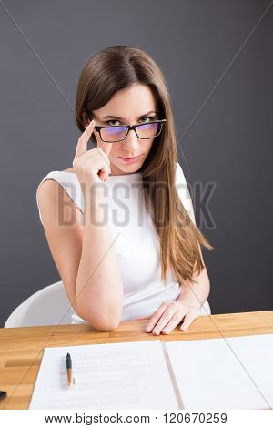 Businesswoman Looking Suspiciously Over Glasses