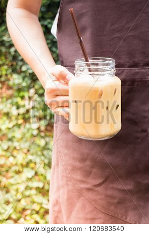 Barista Serving Iced Coffee In The Garden With Vintage Filter Effect