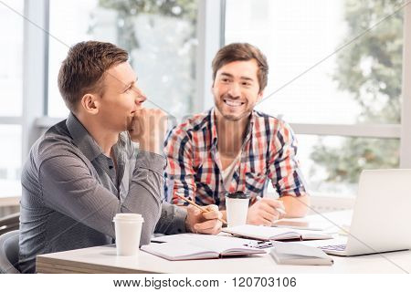 Pleasant men sitting at the table