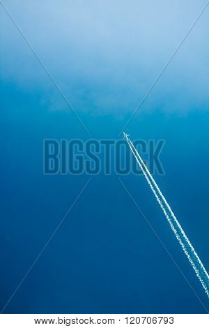 Airplane In Sky With Plane Trails